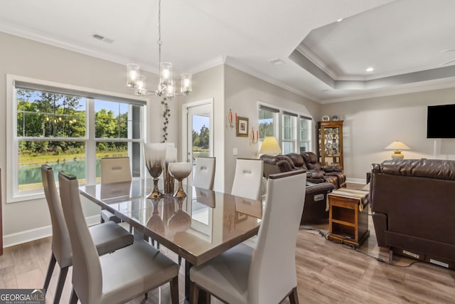 dining area featuring a notable chandelier, visible vents, ornamental molding, and a wealth of natural light
