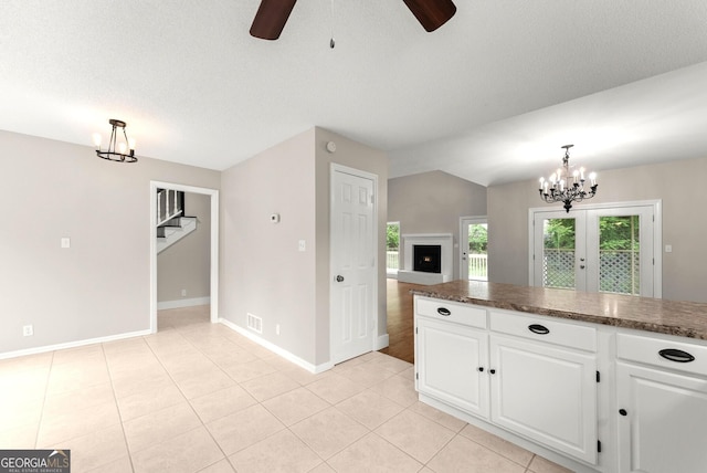 1155 Springway Dr, Gainesville, GA 30501 - kitchen with dark countertops, baseboards, ceiling fan with notable chandelier, and white cabinetry