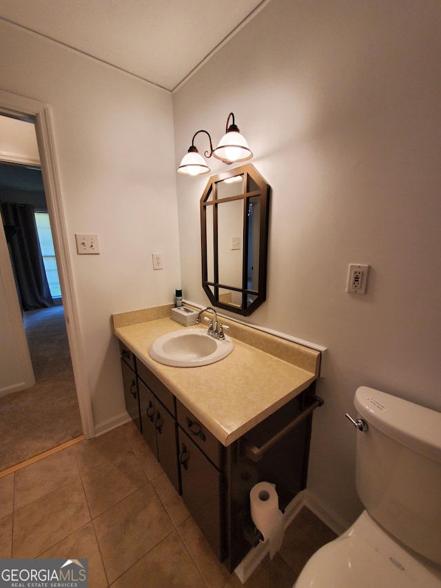 bathroom featuring vanity, tile patterned flooring, baseboards, and toilet