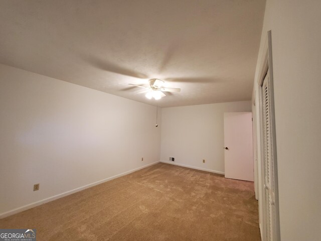 unfurnished bedroom with baseboards, light colored carpet, and ceiling fan