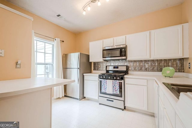 3746 Berkeley Xing, Duluth, GA 30096 - kitchen with backsplash, appliances with stainless steel finishes, light countertops, light floors, and white cabinetry