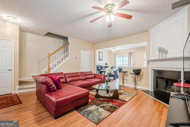 3746 Berkeley Xing, Duluth, GA 30096 - living room featuring a textured ceiling, ceiling fan, and stairway