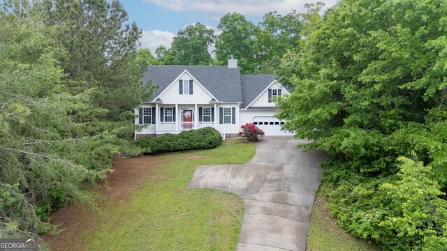 314 Kings Pointe Dr SW, Calhoun, GA 30701 - view of front of property with a shingled roof, a front yard, a chimney, covered porch, and driveway