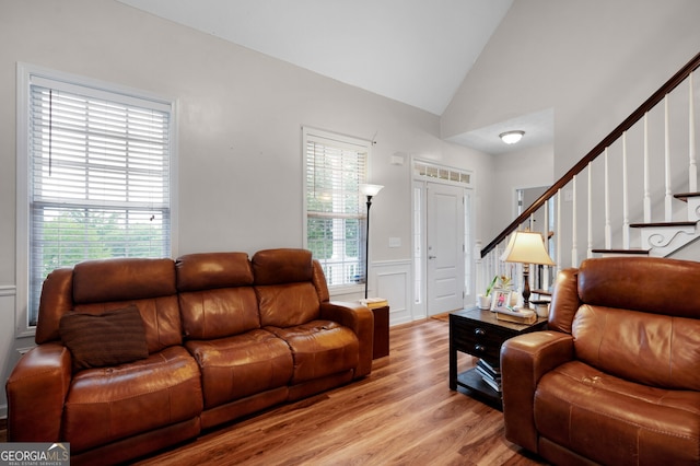 314 Kings Pointe Dr SW, Calhoun, GA 30701 - living room featuring stairs, wainscoting, a decorative wall, light wood-style flooring, and vaulted ceiling