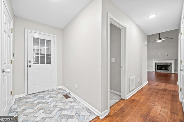 interior space with baseboards, ceiling fan, and a fireplace