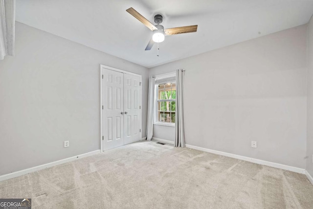 unfurnished bedroom with a ceiling fan, baseboards, carpet, and a closet