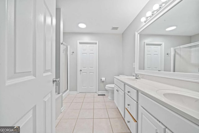 full bathroom with double vanity, tile patterned floors, a stall shower, and toilet