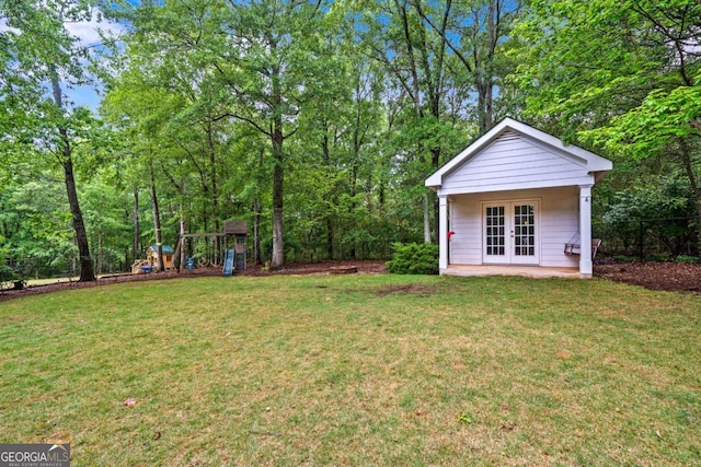 view of yard featuring a playground, fence, and french doors