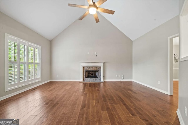 unfurnished living room featuring a fireplace, high vaulted ceiling, a ceiling fan, baseboards, and wood finished floors