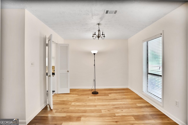 unfurnished dining area featuring visible vents, light wood-style floors, and a healthy amount of sunlight