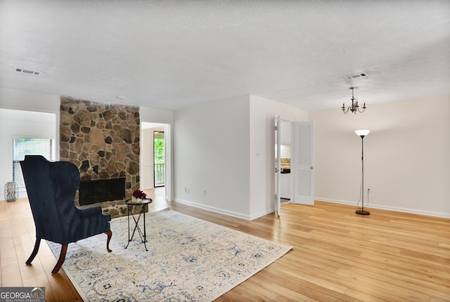 living area with baseboards, a chandelier, visible vents, and light wood-type flooring