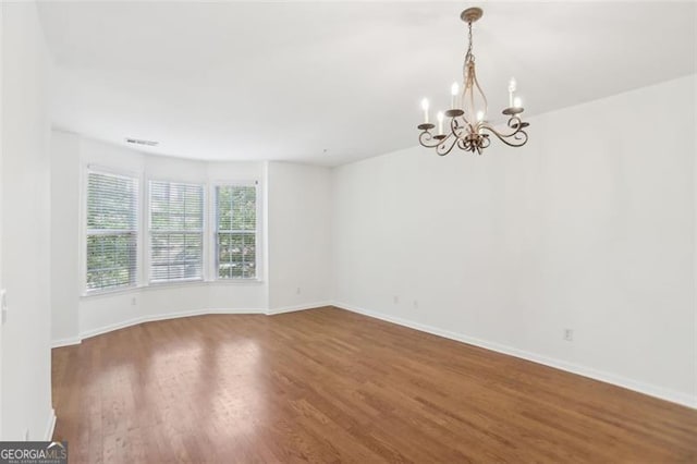 6080 Indian Wood Cir, Mableton, GA 30126 - unfurnished room with baseboards, wood finished floors, a chandelier, and visible vents