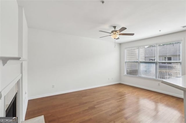 6080 Indian Wood Cir, Mableton, GA 30126 - unfurnished living room featuring a fireplace with flush hearth, baseboards, a ceiling fan, and wood finished floors