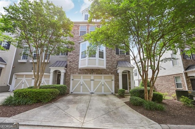 6080 Indian Wood Cir, Mableton, GA 30126 - view of property with a standing seam roof, driveway, metal roof, and a garage