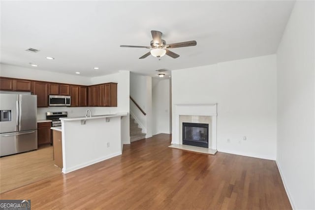 6080 Indian Wood Cir, Mableton, GA 30126 - kitchen with open floor plan, a kitchen breakfast bar, light countertops, a ceiling fan, and appliances with stainless steel finishes