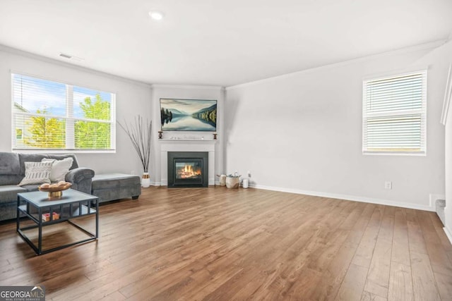 3135 Ellenton Dr, Lithia Springs, GA 30122 - living room featuring ornamental molding, hardwood / wood-style floors, and a glass covered fireplace