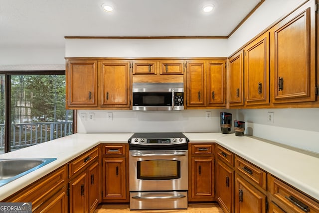 kitchen featuring brown cabinetry, light countertops, appliances with stainless steel finishes, and recessed lighting