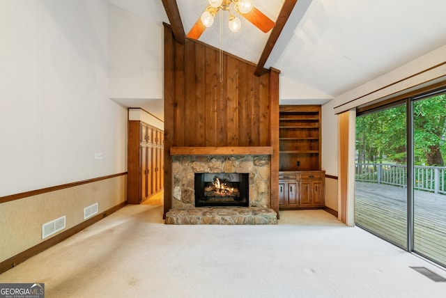 unfurnished living room featuring carpet flooring, ceiling fan, visible vents, and a stone fireplace