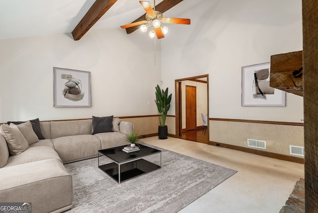 living room with carpet flooring, ceiling fan, visible vents, and beam ceiling