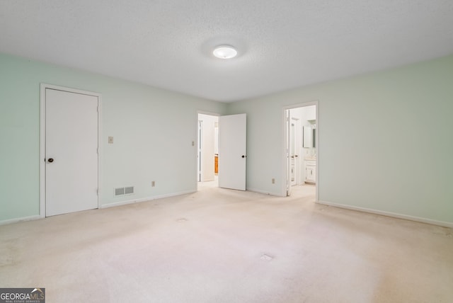 unfurnished bedroom with baseboards, light carpet, and visible vents