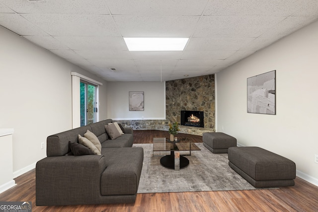 living room with baseboards, visible vents, wood finished floors, and a fireplace
