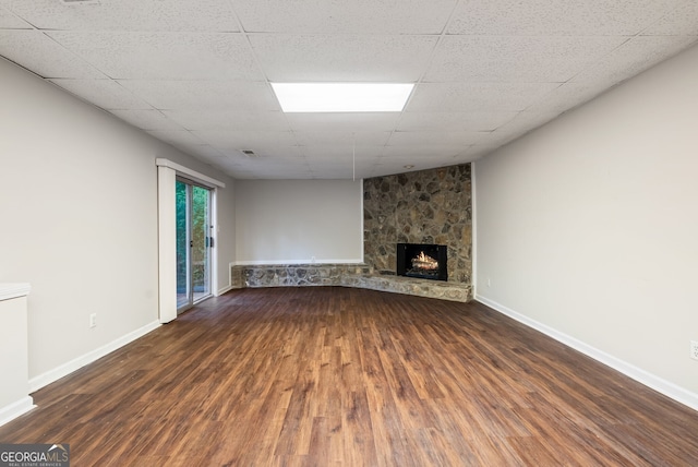unfurnished living room featuring baseboards, wood finished floors, and a fireplace