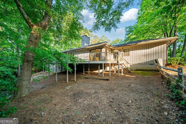rear view of house with a deck, a chimney, and stairs