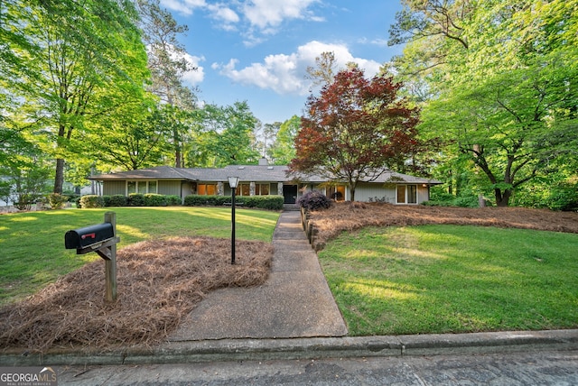 ranch-style house with a chimney and a front lawn
