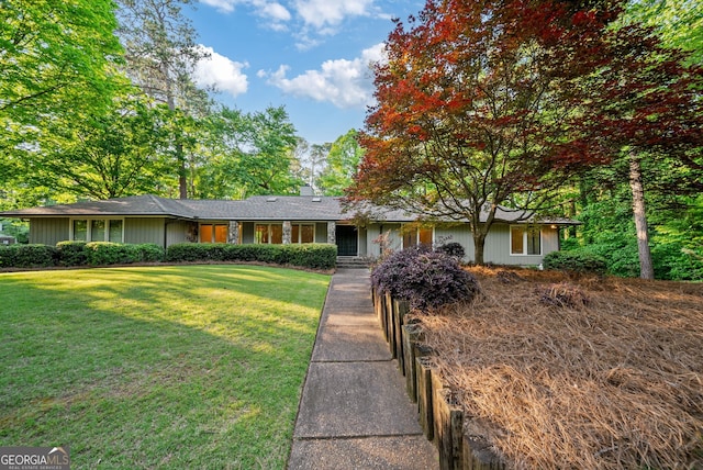 ranch-style house featuring a chimney and a front yard