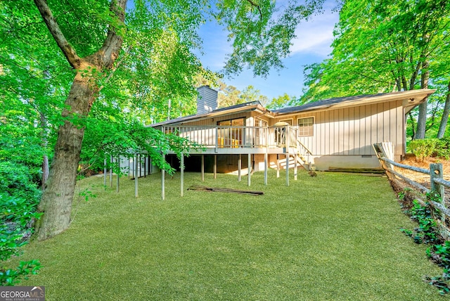 back of house with a lawn, a wooden deck, stairs, and a chimney