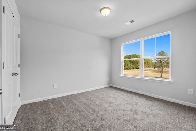unfurnished room featuring carpet floors, baseboards, and visible vents