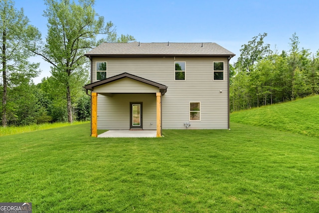 rear view of property with a yard and a patio area