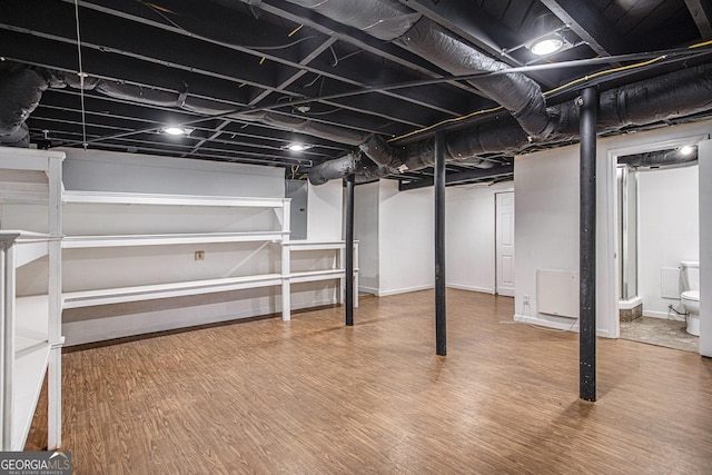 finished below grade area with baseboards and wood finished floors