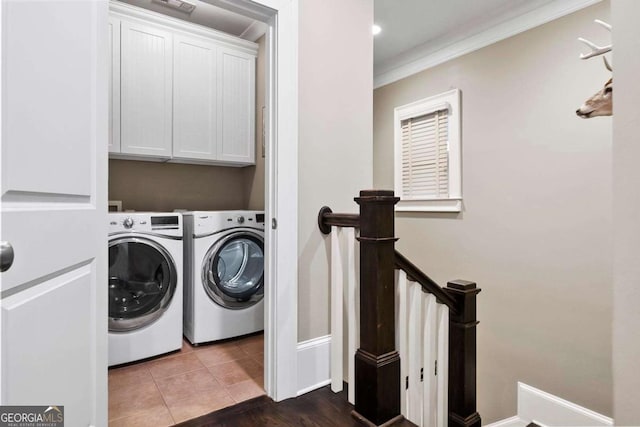 laundry room with baseboards, washer and clothes dryer, cabinet space, and ornamental molding