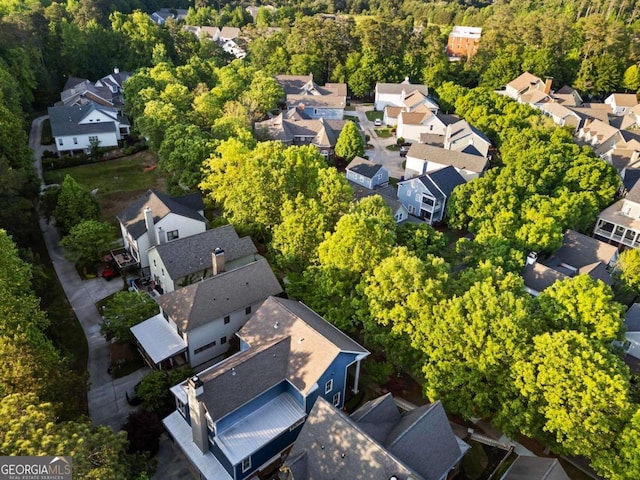 drone / aerial view featuring a residential view and a wooded view