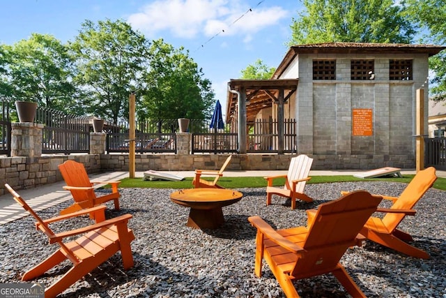 view of playground featuring a fire pit and fence