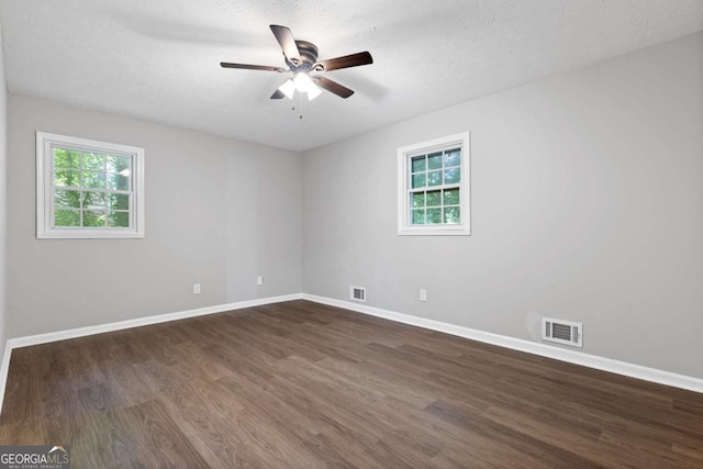 353 Old Rosser Rd, Stone Mountain, GA 30087 - unfurnished room with a healthy amount of sunlight, ceiling fan, dark wood-style floors, and visible vents