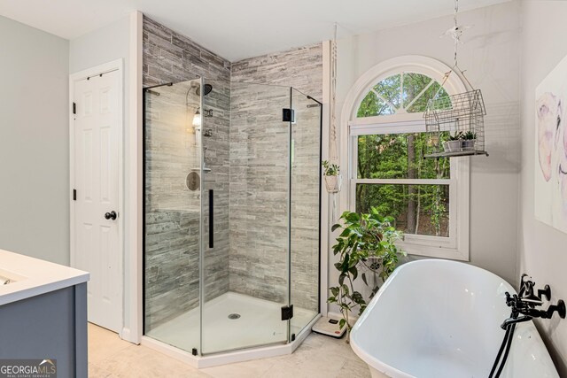 full bath with vanity, a soaking tub, and a stall shower