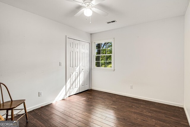 unfurnished bedroom with baseboards, dark wood finished floors, and visible vents