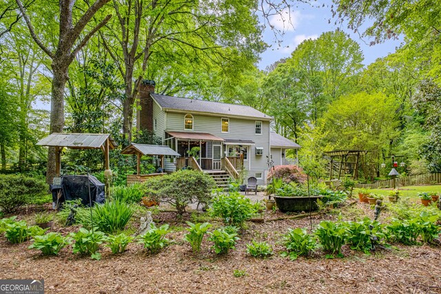 view of front of property featuring a porch, a front lawn, and a chimney