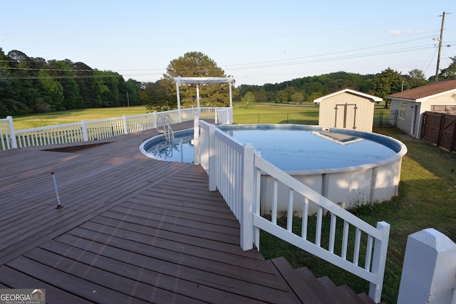 2647 Mount Carmel Rd, Hampton, GA 30228 - view of swimming pool featuring an outdoor structure, a deck, a fenced in pool, a lawn, and a storage shed