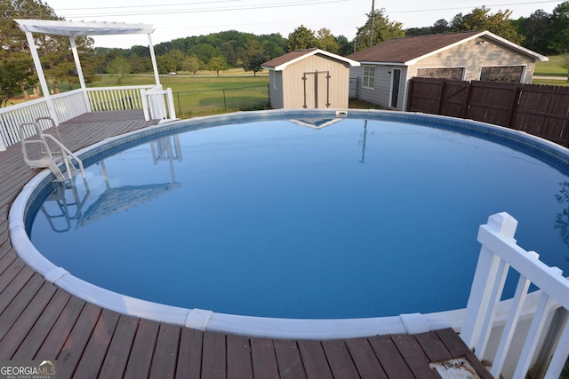 2647 Mount Carmel Rd, Hampton, GA 30228 - view of swimming pool featuring an outdoor structure, fence, a deck, a shed, and a fenced in pool
