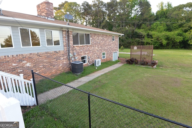 2647 Mount Carmel Rd, Hampton, GA 30228 - view of home's exterior featuring fence, a chimney, brick siding, central air condition unit, and a yard