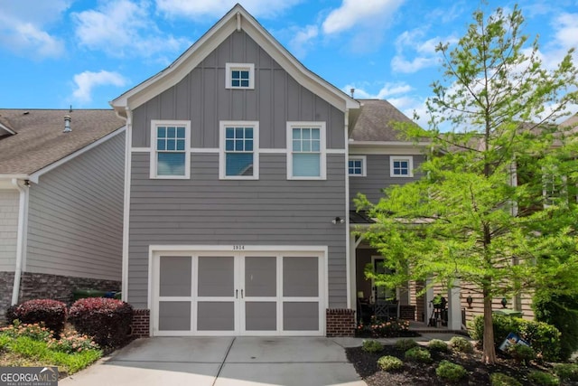 1914 Coal Pl, Atlanta, GA 30318 - view of front of house featuring a garage, board and batten siding, concrete driveway, and brick siding