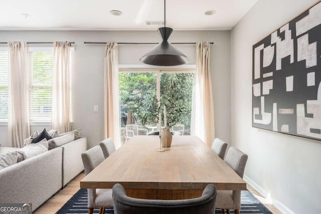 dining area featuring baseboards, plenty of natural light, and light wood-style flooring