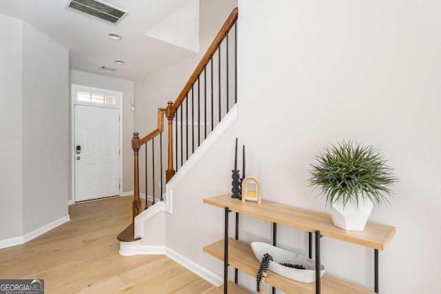foyer entrance featuring light wood finished floors, stairs, recessed lighting, baseboards, and visible vents