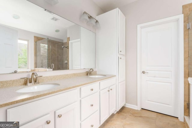 full bath featuring a sink, a stall shower, double vanity, and visible vents
