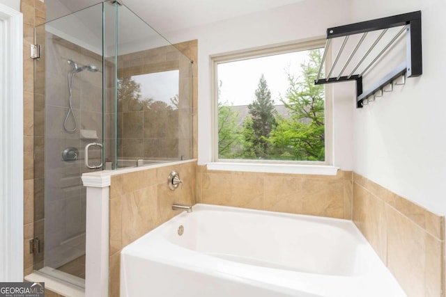 bathroom featuring a stall shower and a garden tub