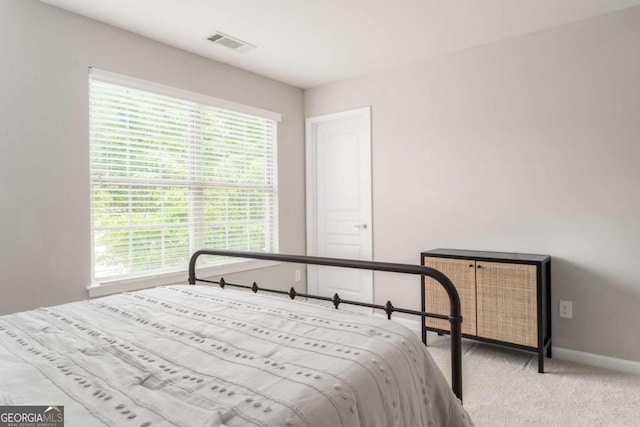 carpeted bedroom with visible vents and baseboards