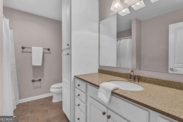 full bathroom featuring vanity, baseboards, a skylight, and toilet